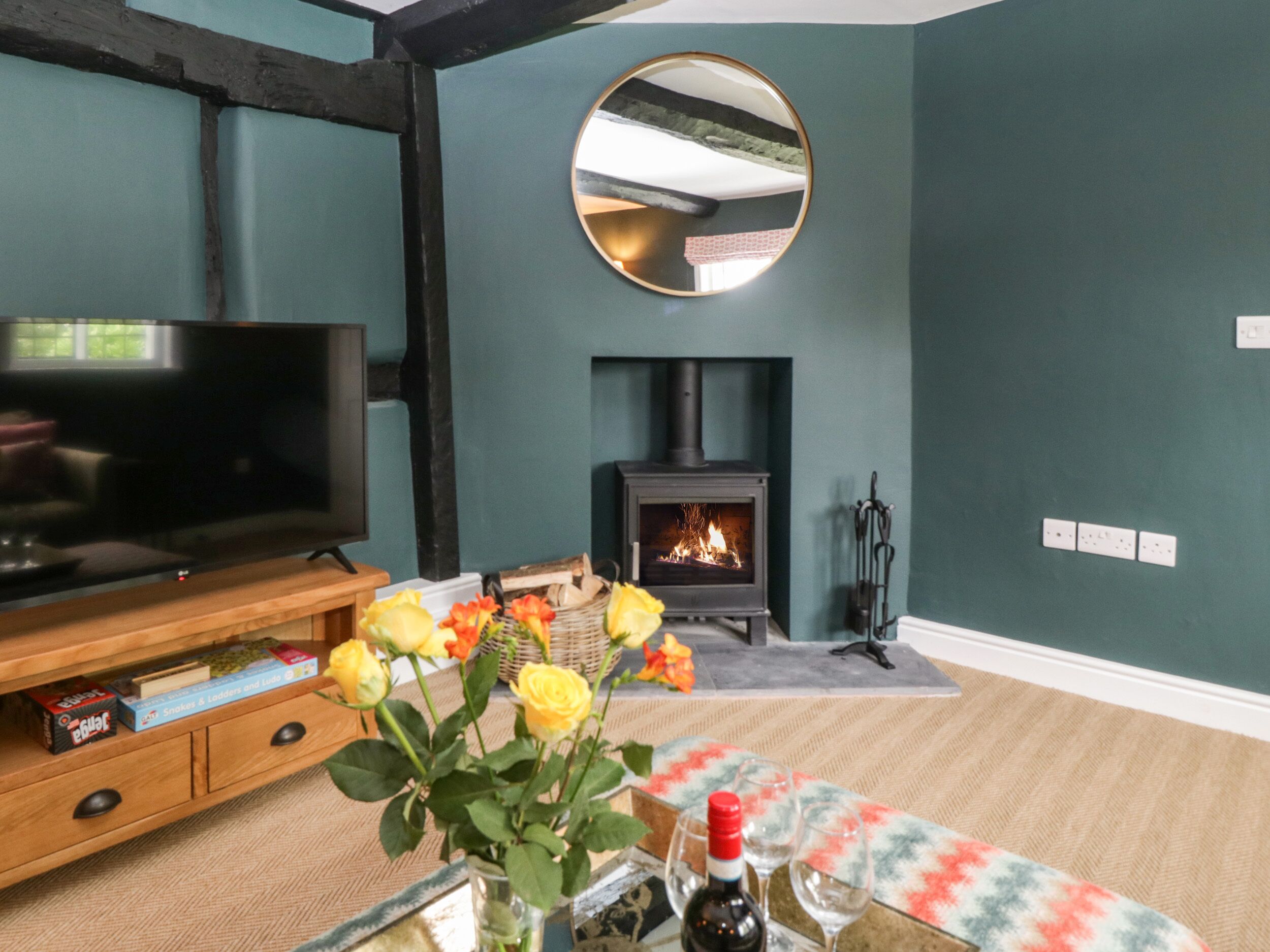Una sala de estar con televisor, chimenea y un espejo en la pared.