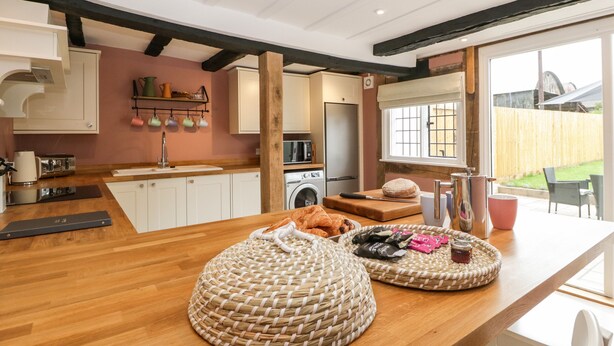 Una cocina moderna con encimeras de madera, horno integrado y un ventanal grande.