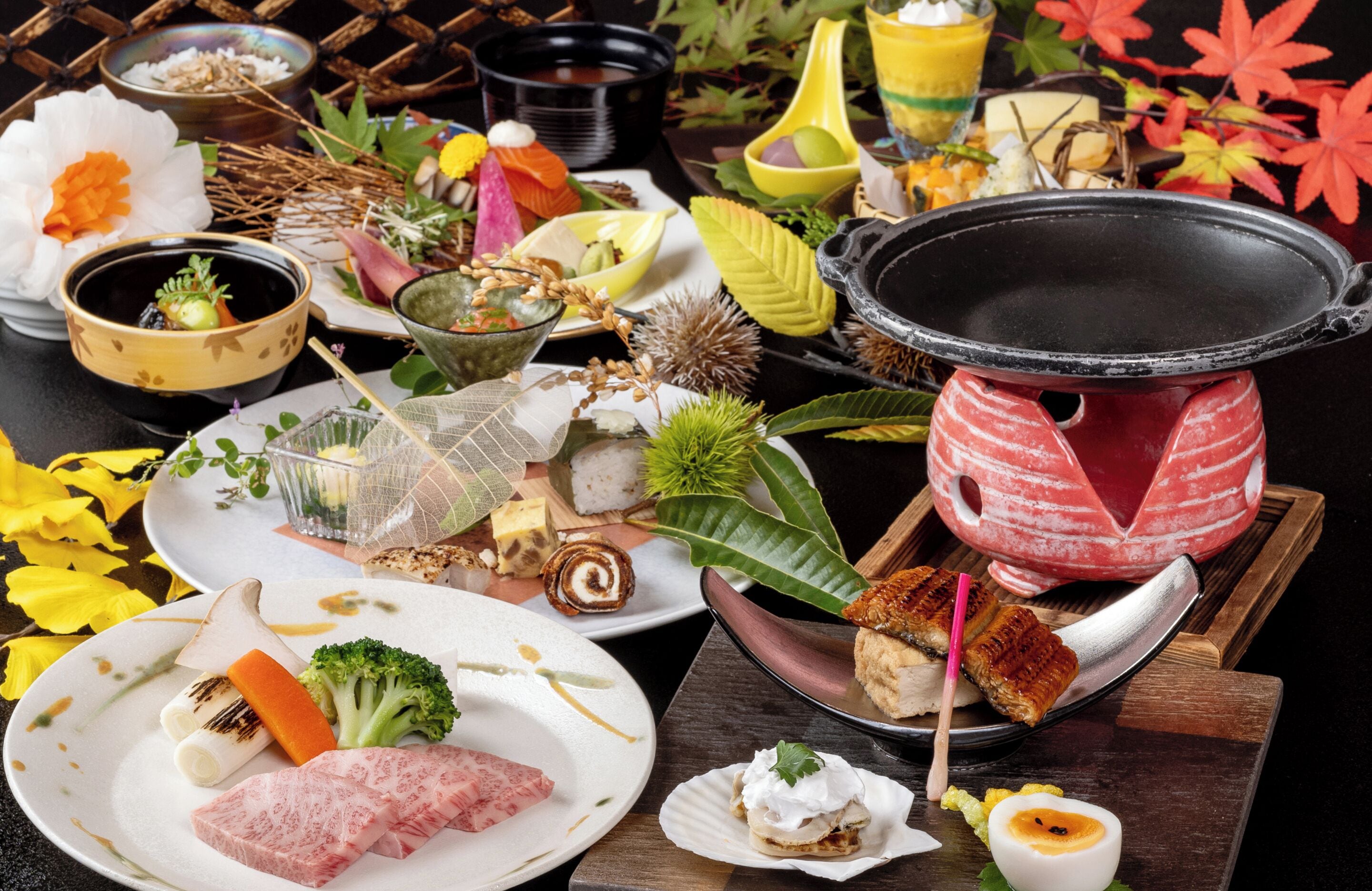 A variety of dishes and a hot pot setup on a table.