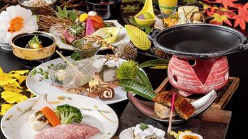 A variety of dishes and a hot pot setup on a table.
