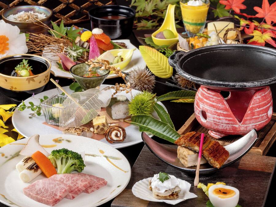 A variety of dishes and a hot pot setup on a table.