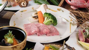 A plate with various food items including sliced meat, vegetables, and a roll.