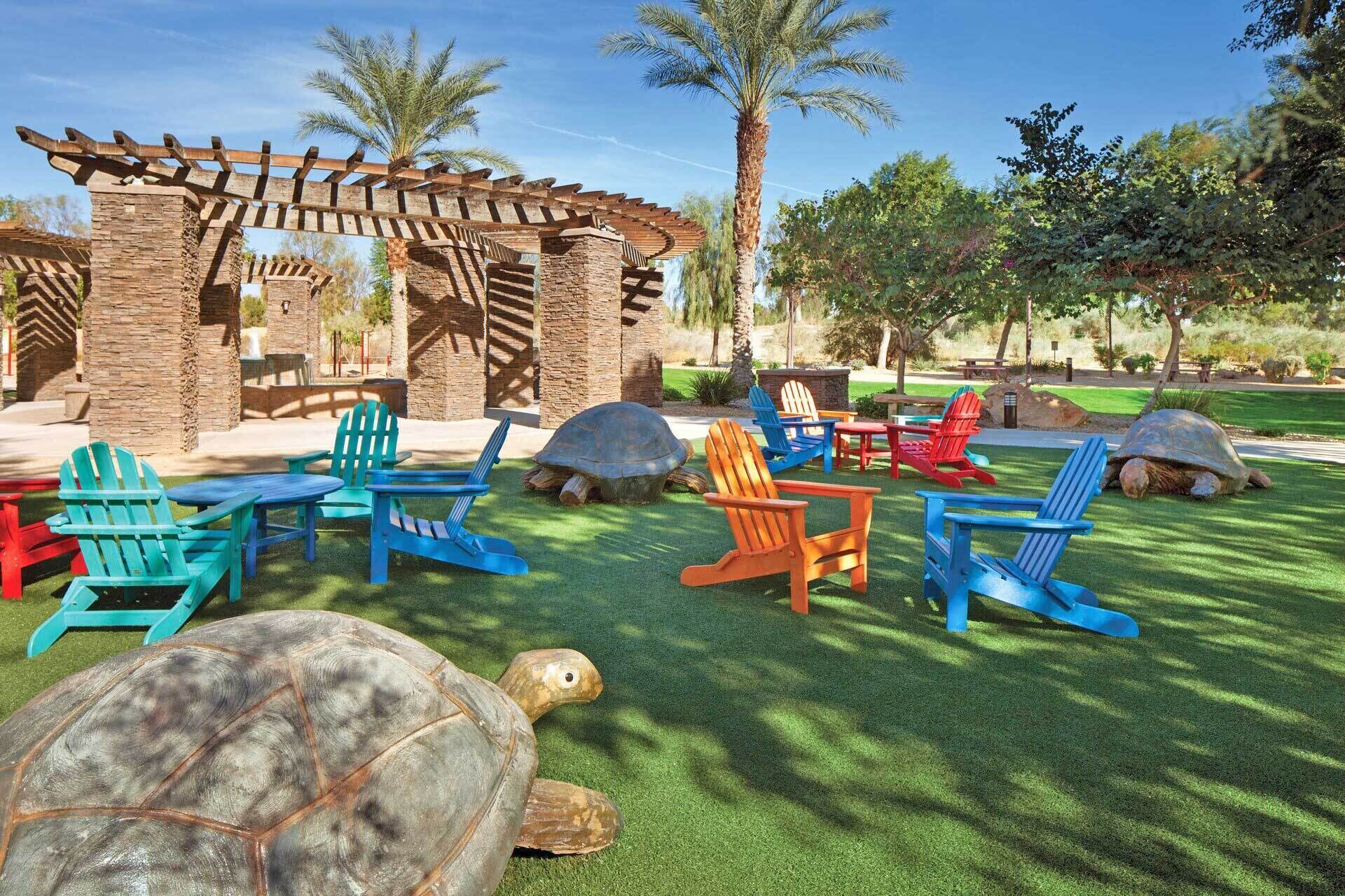 A patio area with Adirondack chairs, a wooden pergola, and a turtle.