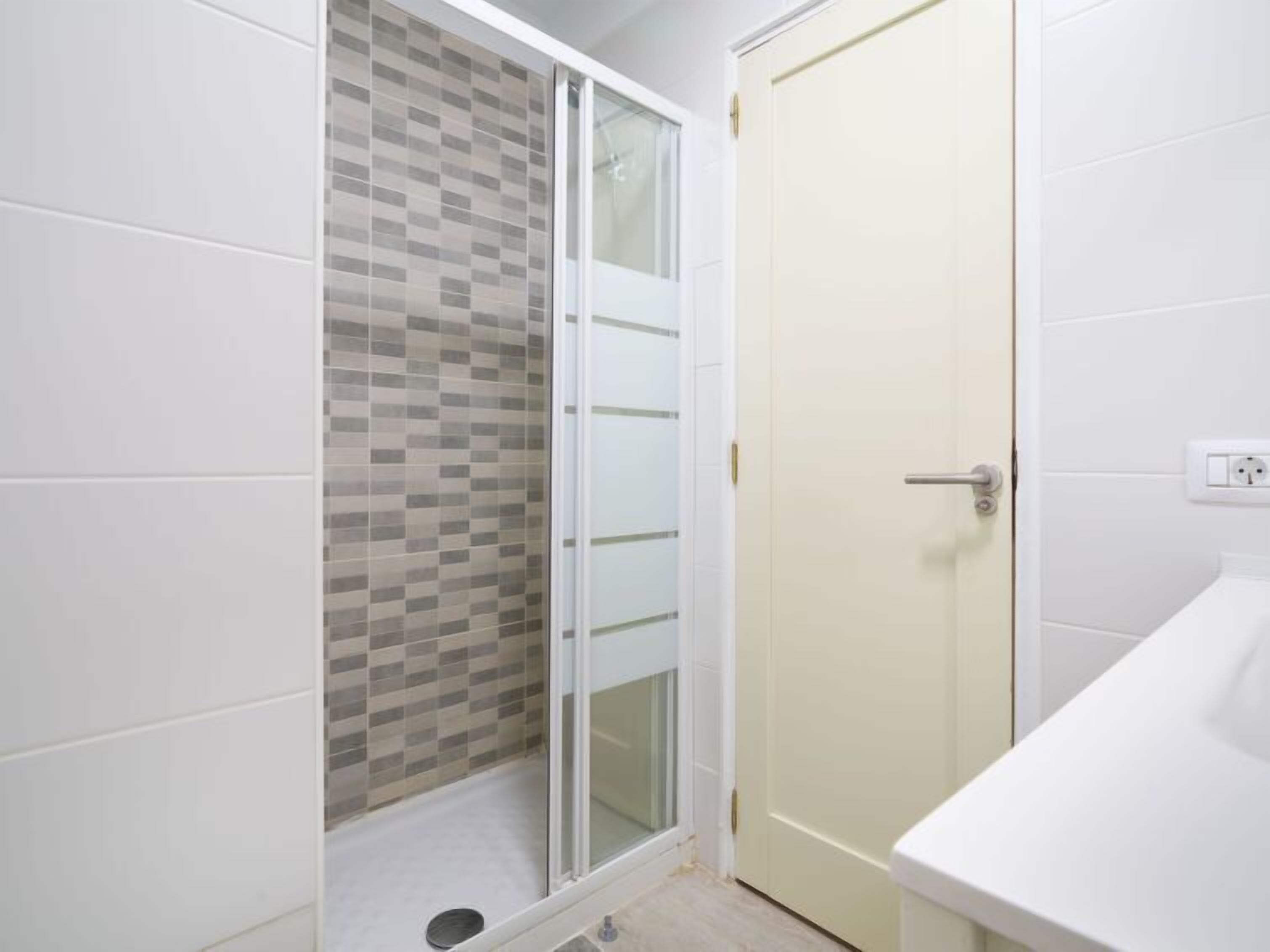 A bathroom with a shower, a toilet, and a sink.