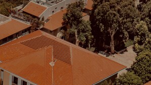 Ett flygbildsbild av ett bostadsområde med flera byggnader som har röda tegeltak och balkonger.