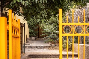 A pathway leading to a building with a yellow gate.