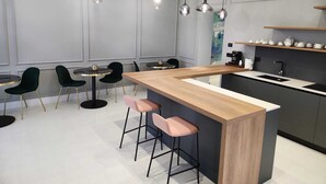 Una cocina moderna con una isla central, taburetes de bar e iluminación colgante.