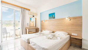 A hotel room with two beds, a bathroom, a desk, and a balcony.