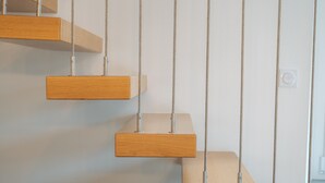 A series of wooden platforms suspended by metal chains against a plain wall. - Holiday Home 'Le Banc Des Hermelles' with Private Terrace, Private Garden and Wi-Fi (Saint-Benoît-des-Ondes)