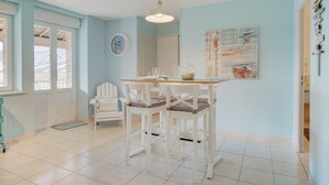 Una habitación con una mesa de comedor, sillas, un reloj y una puerta.