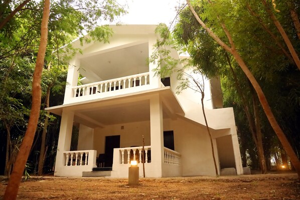 A two-story building with a balcony, surrounded by trees. - Panna Tiger Resort- River Side Property (Panna)