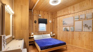 A wooden-paneled room with a bed, a vanity with lights, a window, and wall art. - Holiday Home "Casa Tenerife Primera Linea" with Sea Views, 3 Private Terraces and Wi-Fi (tenerife)