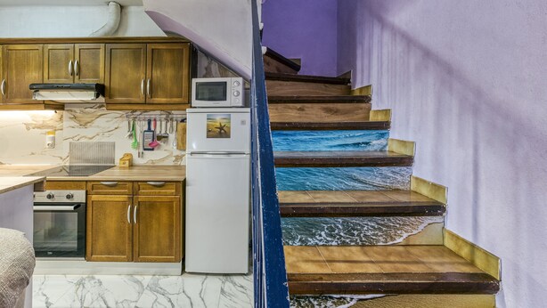 A kitchen with wooden cabinets, a microwave, and a refrigerator. - Vacation Home "Casa Empuriabrava Con Terraza" with 2 Private Terraces & Private Garden (Castelló d'Empúries)