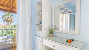 A bathroom with a glass vanity, a heart-shaped mirror, and a potted lavender plant. - Studio Apartment 'Angelina 2' with Mountain View, Wi-Fi and Air Conditioning (Corfu)