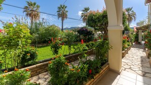 Un jardín con un sendero de piedra, palmeras y una variedad de plantas.