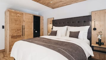 Una camera da letto con un letto grande, un'armadio in legno e un soffitto a vista con travi.
