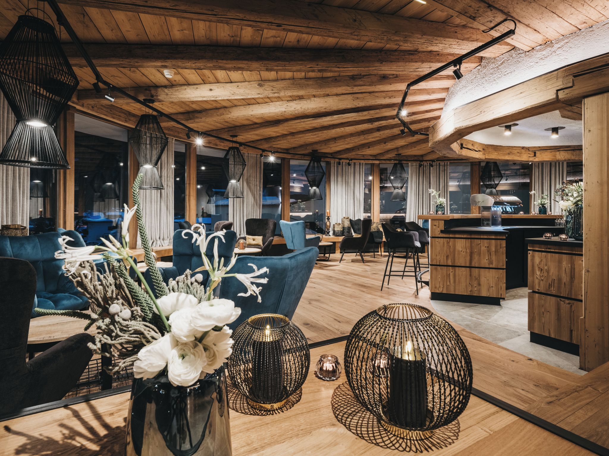 A modern interior with wooden ceilings, a dining area, and a kitchen.