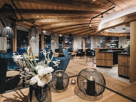 A modern interior with wooden ceilings, a dining area, and a kitchen.