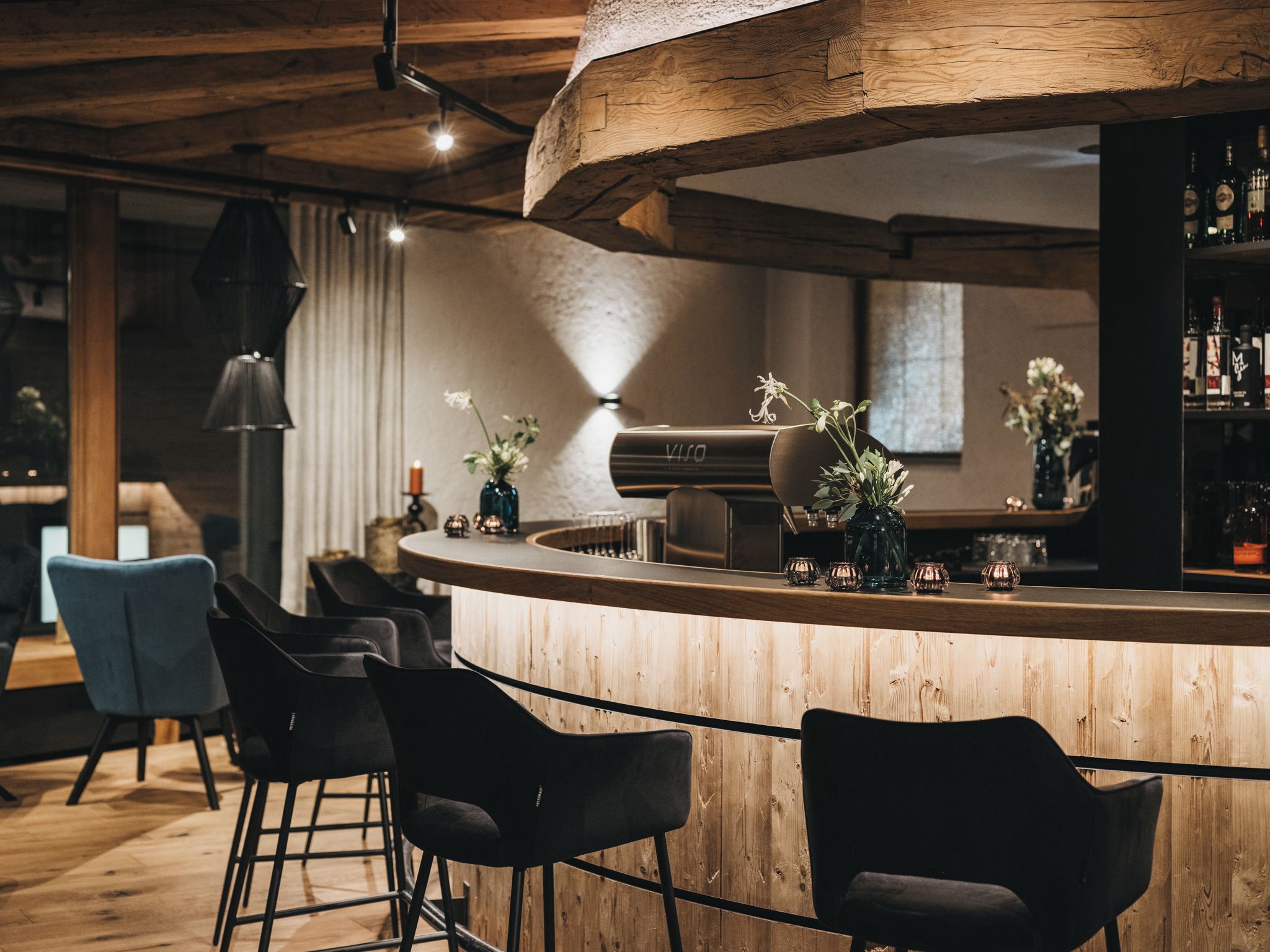 Een bar met houten meubels, een piano en een keuze uit flessen.