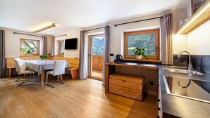 A modern kitchen with a wooden countertop, a built-in sink, and a view of a mountainous landscape through large windows. - Apartment 'Bergchalet Prantach W75' with Mountain View, Shared Terrace and Wi-Fi (San Martino In Passiria)