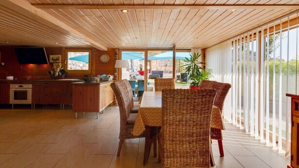 A modern kitchen with wooden cabinets and a large window.
