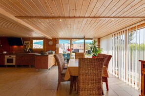 A modern kitchen with wooden cabinets and a large window. - Riverside Chalet Retreat (Le Cheylard)