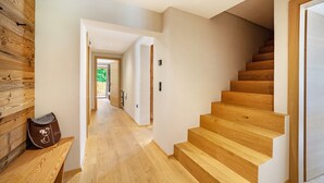 A wooden staircase leading to a landing, a bench with a cushion, and a wooden wall. - Apartment 'Bergchalet Prantach W95' with Mountain View, Shared Terrace and Wi-Fi (San Martino In Passiria)