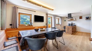 A modern kitchen with a dining area, wooden flooring, and large windows. - Apartment 'Bergchalet Prantach W95' with Mountain View, Shared Terrace and Wi-Fi (San Martino In Passiria)