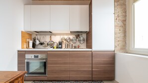 Eine Küche mit Holzausstattung, einem eingebauten Backofen und einer gefliesten Spritzschutzwand.