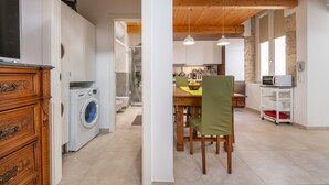 Eine moderne Küche mit Essbereich, Holzboden und einer Waschmaschine.