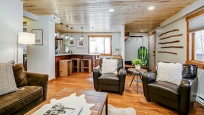 Un soggiorno moderno con divani in pelle, un tavolino da caffè e un'area pranzo con sgabelli in legno.