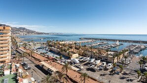 A coastal marina with boats, a pier, and a building with a dome.