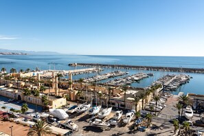 Un port de plaisance avec des bateaux amarrés, une jetée s’avançant dans l’eau et un bâtiment doté d’une structure en forme de dôme.