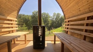 Una sauna con bancos de madera y una unidad de calefacción central.