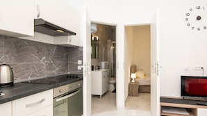 A modern kitchen with a stove, oven, and marble backsplash.