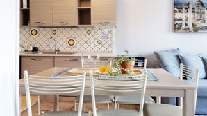 Une cuisine moderne avec des meubles en bois, un pare-feu en carreaux et un coin repas avec une table mise pour deux personnes.