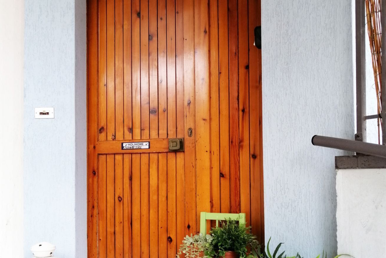 A wooden door with a sign that reads "HOLIHOME."