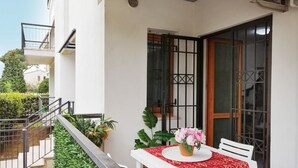 A balcony with a table, potted plants, and a view of the surrounding area. - HoliHome_Nobil Villani (Tortoreto Lido)