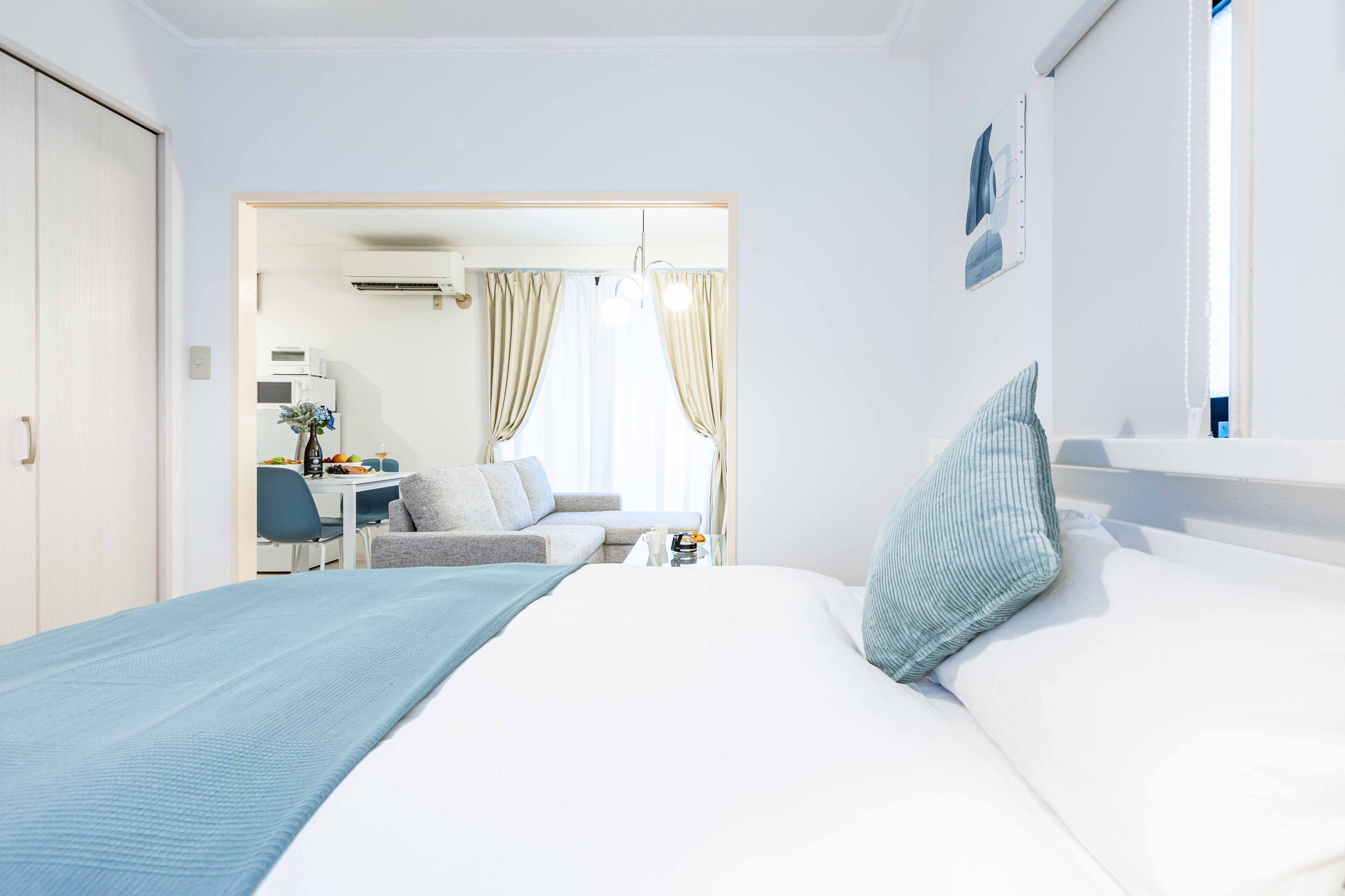 A hotel room with a bed, a desk, and a chair.