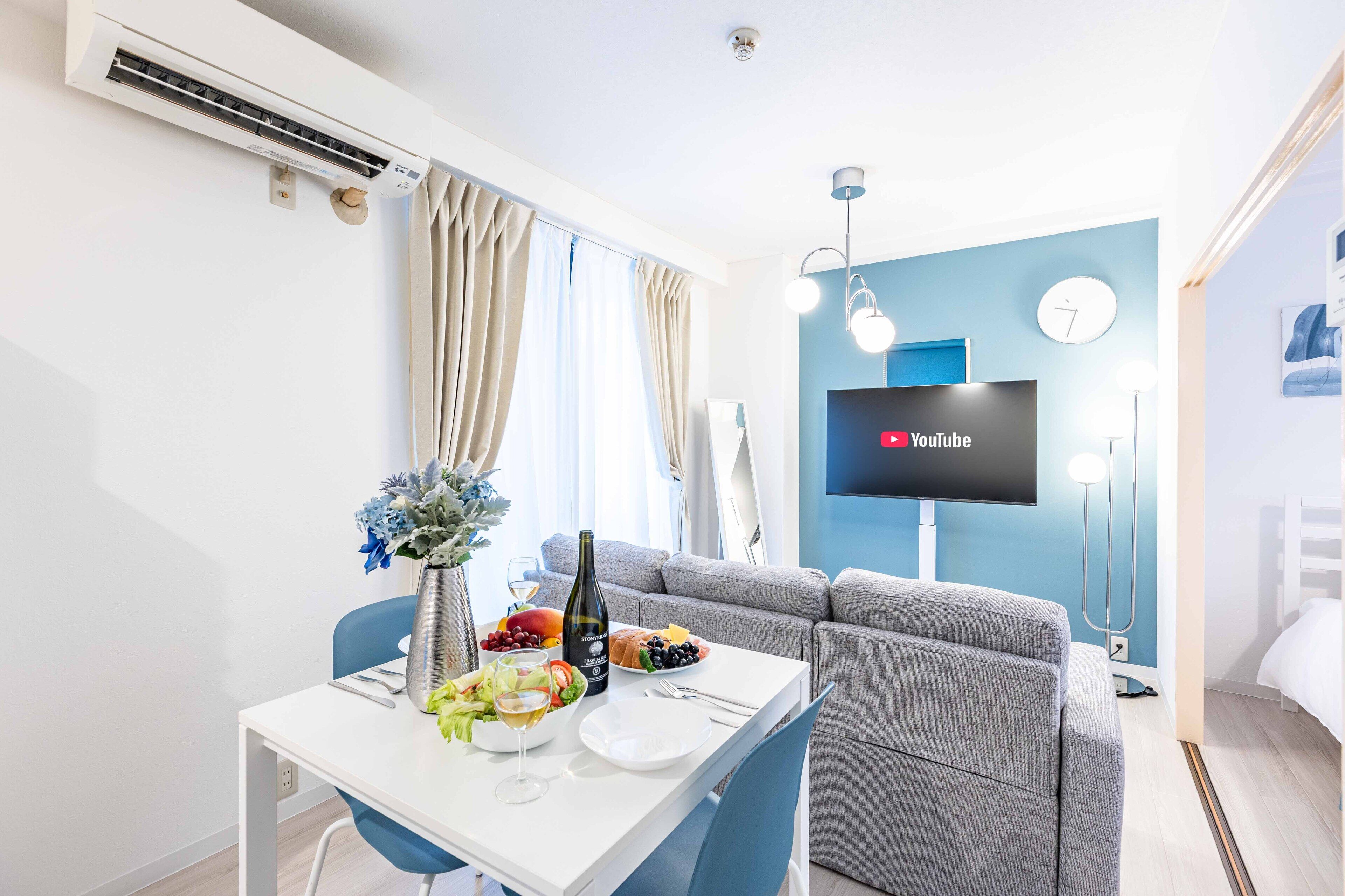Ein modernes Hotelzimmer mit Essbereich, Flachbildfernseher und Sofa.