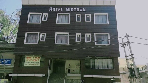 A hotel named "Hotel Midtown" with a sign for available space and a visible staircase leading to the entrance. - Hotel Midtown (Palwal)
