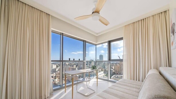 Ein modernes Wohnzimmer mit großem Fenster, Deckenventilator und einer Couch.