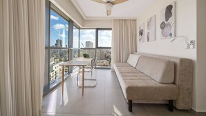 Ein modernes Wohnzimmer mit einer Couch, einem Esstisch und einem Deckenventilator.
