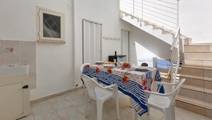 A dining area with a table set for two, a white staircase, and a view of the sky. - 3550 Casa Cleopatra by Barbarhouse (Porto Cesareo)