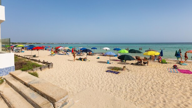 A beach with multiple umbrellas, people relaxing, and a clear sky. - 3550 Casa Cleopatra by Barbarhouse (Porto Cesareo)