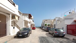 A narrow street lined with parked cars and residential buildings. - 3550 Casa Cleopatra by Barbarhouse (Porto Cesareo)