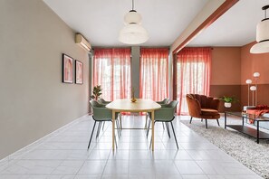 Un espace de salle à manger moderne avec une table ronde, des chaises et un luminaire suspendu.