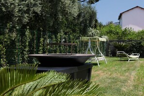 A patio area with a table and chairs, surrounded by a fence and greenery. - Villa Massa residence Sorrento (Sant Agnello)