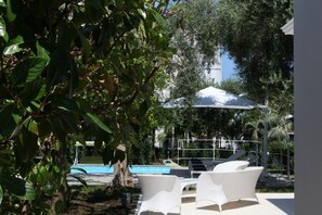 A pool area with white lounge chairs and a covered seating area. - Villa Massa residence Sorrento (Sant Agnello)