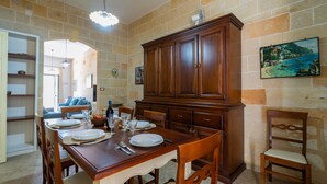 A dining area with a wooden table set for four, flanked by a large cabinet and a chair. - 3450 Casa Maredoro by Barbarhouse (Nardò)